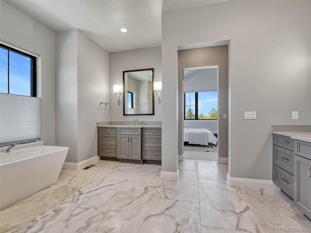 full bath featuring marble finish floor, vanity, and baseboards