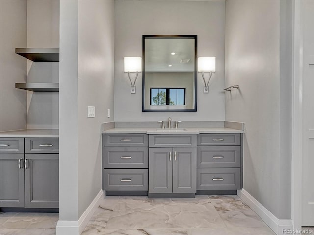 bathroom featuring marble finish floor, vanity, and baseboards