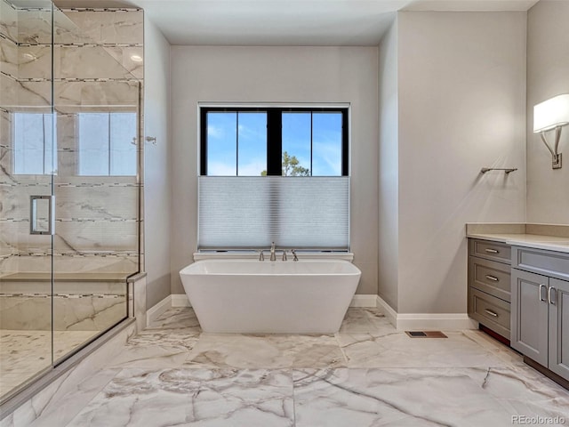 bathroom featuring vanity, a shower stall, a freestanding tub, and marble finish floor