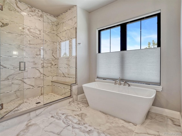 bathroom featuring baseboards, a soaking tub, marble finish floor, and a shower stall