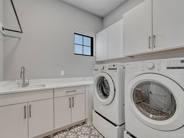 laundry room with washing machine and clothes dryer, cabinet space, light floors, and a sink