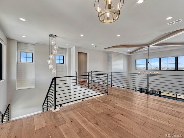 spare room with a chandelier, recessed lighting, and wood-type flooring