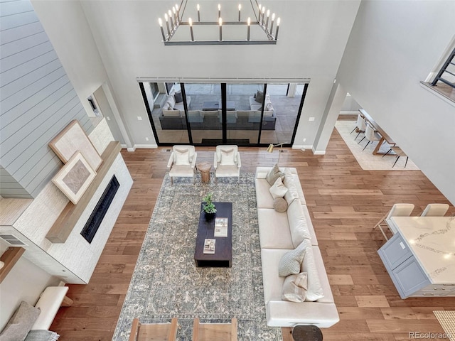 living room featuring a high ceiling, wood finished floors, and baseboards