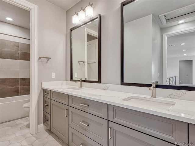 full bath with a sink, toilet, double vanity, and tile patterned flooring