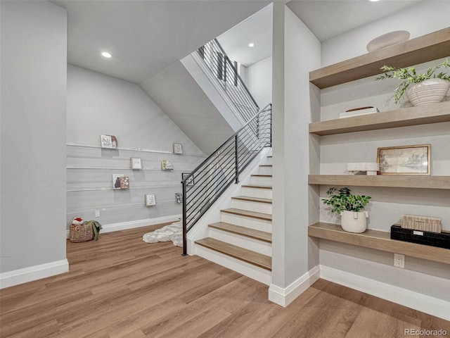 staircase featuring recessed lighting, baseboards, and wood finished floors