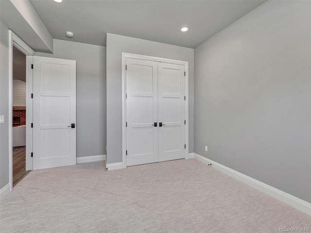 unfurnished bedroom with recessed lighting, a closet, baseboards, and carpet flooring