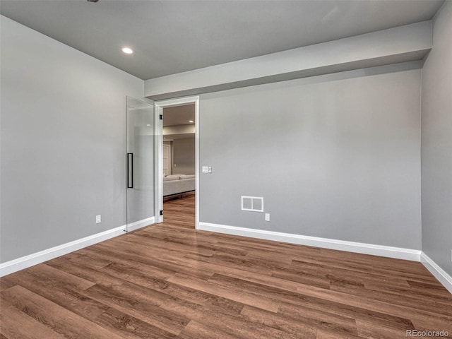 spare room with recessed lighting, visible vents, baseboards, and wood finished floors