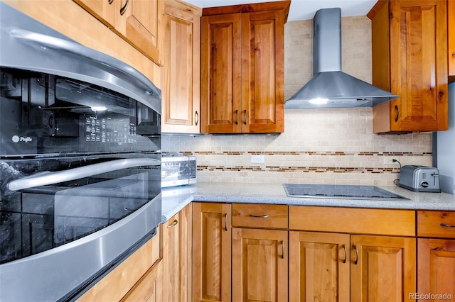 60 Jackson, Alma, CO 80420 - kitchen featuring wall chimney exhaust hood, appliances with stainless steel finishes, backsplash, brown cabinetry, and light stone counters