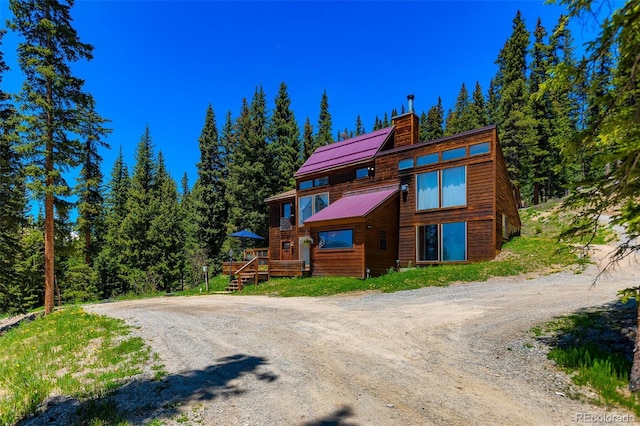 60 Jackson, Alma, CO 80420 - view of front of house with a chimney, dirt driveway, and a metal roof