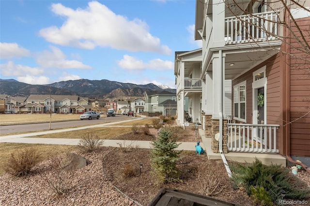 view of yard featuring a mountain view, a residential view, and a balcony