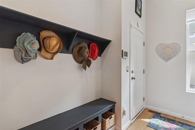 mudroom with visible vents, baseboards, and light wood-style floors