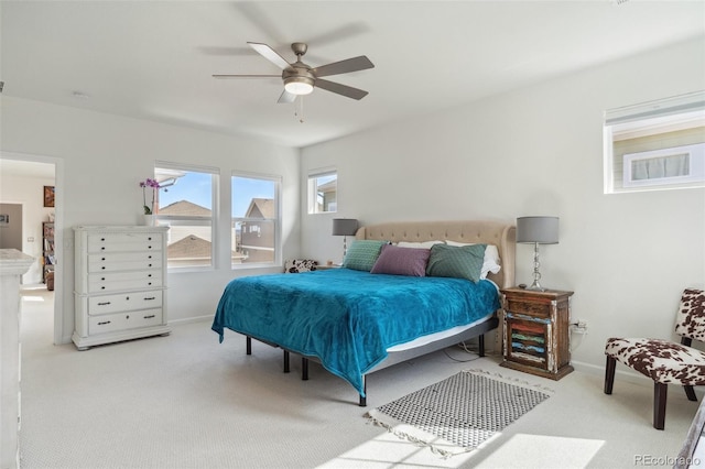 carpeted bedroom featuring baseboards and ceiling fan