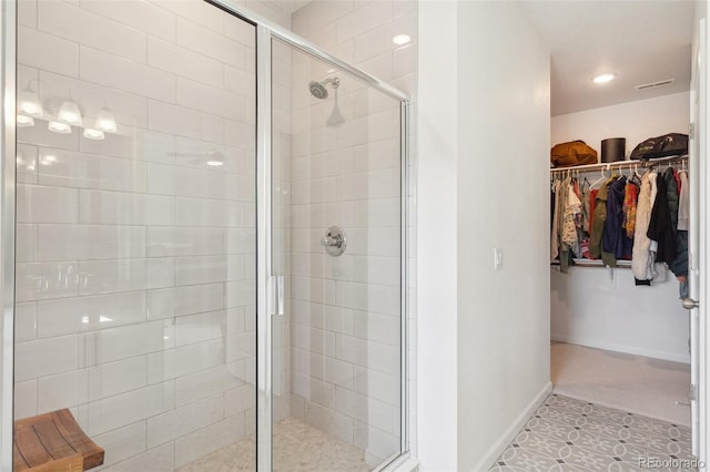 full bath with visible vents, baseboards, a stall shower, and a spacious closet