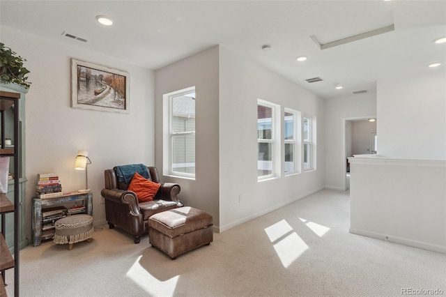 living area featuring recessed lighting, visible vents, and light carpet