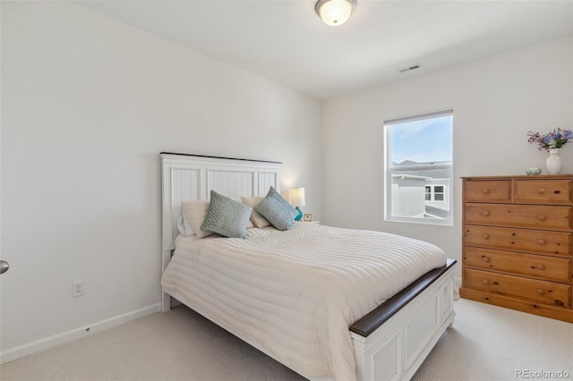 bedroom featuring visible vents, light colored carpet, and baseboards