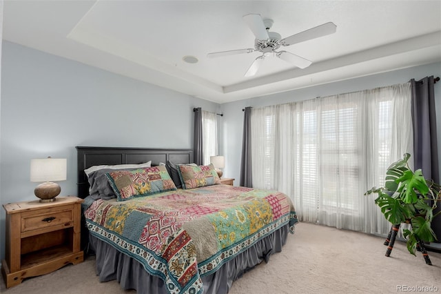 10554 Atwood Cir, Littleton, CO 80130 - bedroom featuring light colored carpet, a raised ceiling, a ceiling fan, and multiple windows