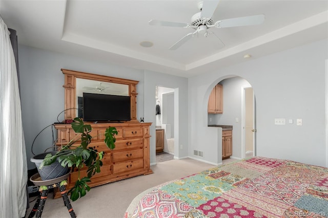 10554 Atwood Cir, Littleton, CO 80130 - bedroom featuring ensuite bath, ceiling fan, light carpet, arched walkways, and a raised ceiling