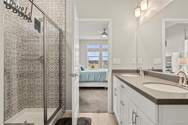 21426 E Stanford Ave, Aurora, CO 80015 - ensuite bathroom with double vanity, a ceiling fan, wood finished floors, and a shower stall