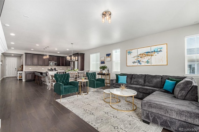 living room with dark hardwood / wood-style flooring and a notable chandelier