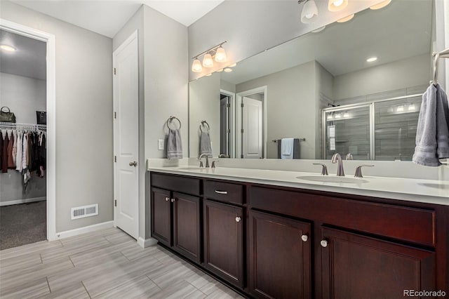 bathroom featuring vanity and a shower with door