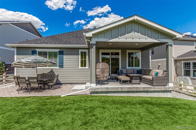 back of house with outdoor lounge area, a patio area, and a lawn