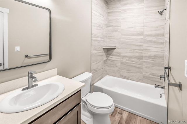 full bathroom with vanity, hardwood / wood-style floors, tiled shower / bath combo, and toilet