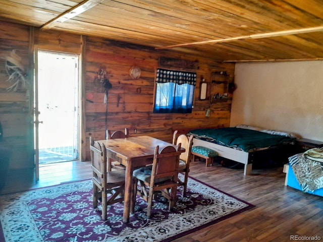 dining room featuring hardwood / wood-style flooring, wooden walls, and wooden ceiling