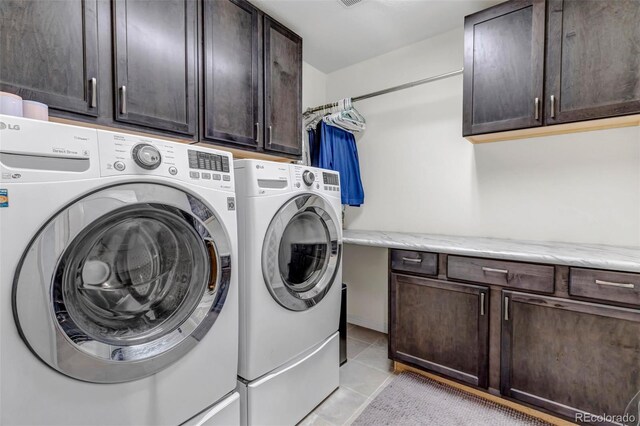 laundry area with light tile patterned floors, cabinet space, and washer and dryer