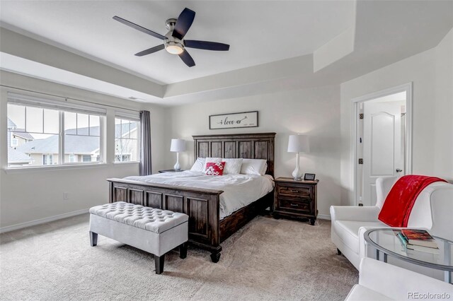 bedroom with visible vents, baseboards, ceiling fan, a tray ceiling, and carpet flooring