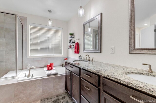 full bath with double vanity, a shower stall, a sink, and a bath