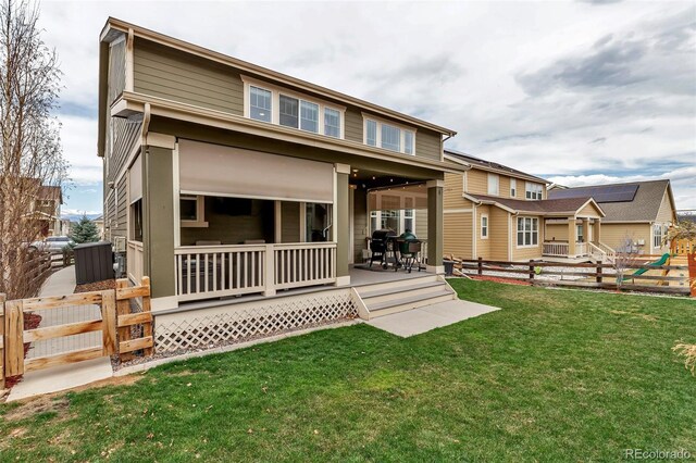 back of property featuring fence, a yard, and a deck