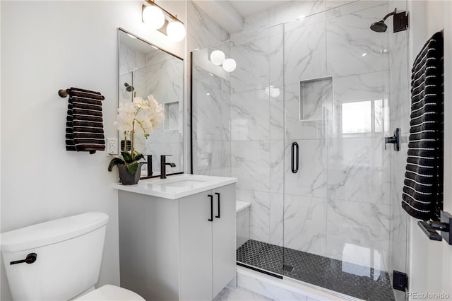 bathroom with a shower with door, vanity, and toilet