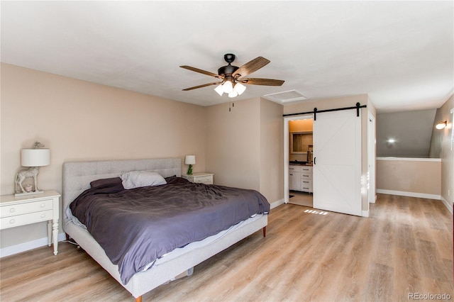 bedroom with baseboards, a barn door, ceiling fan, and light wood finished floors