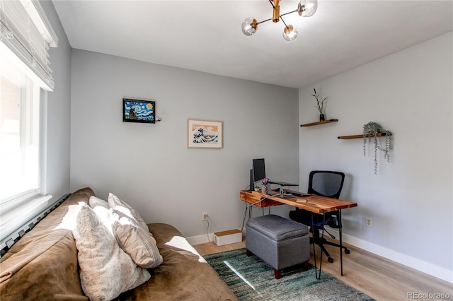 office area with baseboards, wood finished floors, and a notable chandelier