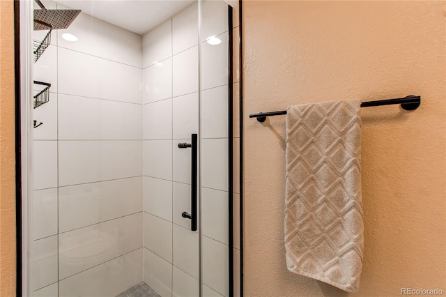 full bathroom featuring a textured wall and a shower stall
