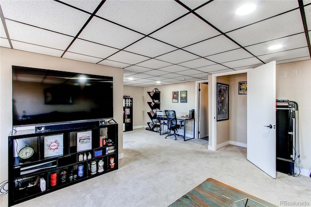 carpeted living area with a drop ceiling and baseboards