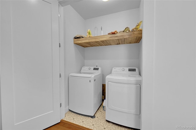 washroom featuring washing machine and clothes dryer and light hardwood / wood-style flooring