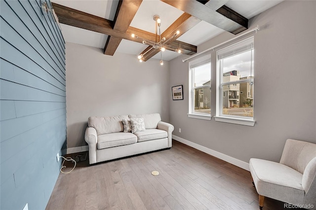 sitting room featuring beam ceiling, coffered ceiling, a notable chandelier, and light wood-type flooring