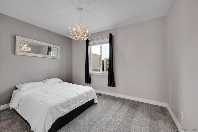 carpeted bedroom with a notable chandelier