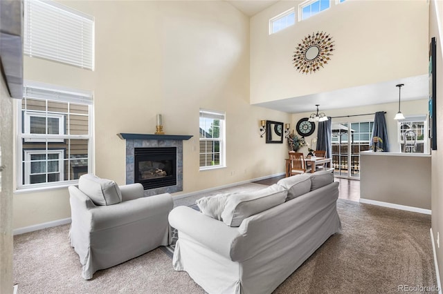 12388 Jasmine St, Brighton, CO 80602 - carpeted living area with a high ceiling, a tile fireplace, and a chandelier