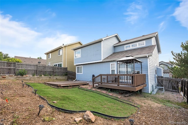 12388 Jasmine St, Brighton, CO 80602 - back of property featuring a wooden deck, a fenced backyard, a gazebo, and a shingled roof