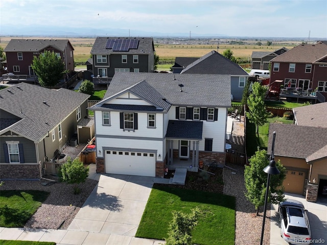 4863 Wildflower Pl, Dacono, CO 80514 - view of front of home with stone siding, a residential view, driveway, a garage, and roof with shingles