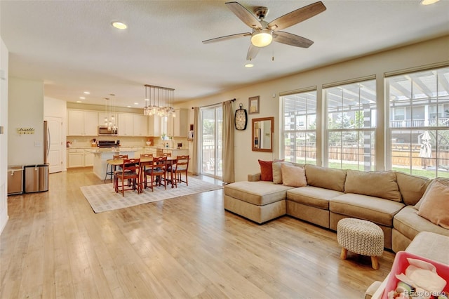 4863 Wildflower Pl, Dacono, CO 80514 - living area featuring a ceiling fan, recessed lighting, light wood finished floors, and a chandelier