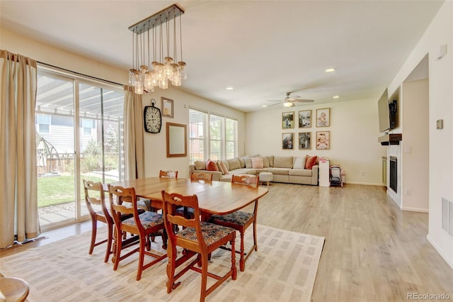 4863 Wildflower Pl, Dacono, CO 80514 - dining space featuring a fireplace, light wood-style floors, recessed lighting, and ceiling fan