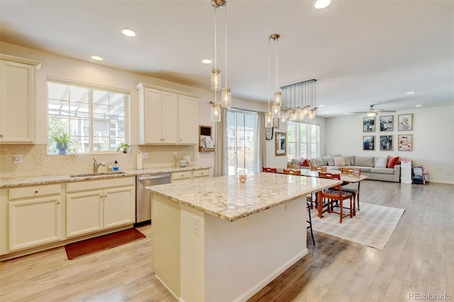4863 Wildflower Pl, Dacono, CO 80514 - kitchen featuring a center island, recessed lighting, tasteful backsplash, light wood-type flooring, and stainless steel dishwasher