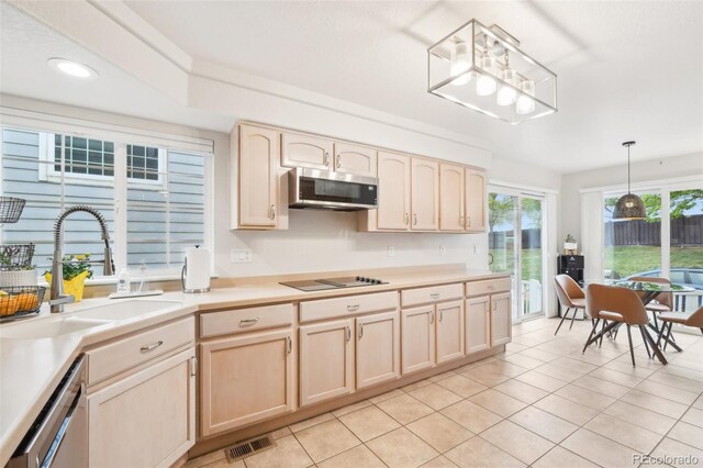 kitchen with appliances with stainless steel finishes, light brown cabinetry, a sink, light countertops, and recessed lighting