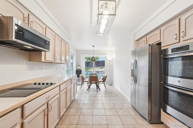 kitchen featuring appliances with stainless steel finishes, light countertops, light brown cabinets, light tile patterned floors, and pendant lighting