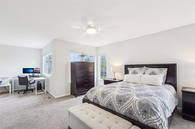 bedroom with an office area, carpet floors, and baseboards