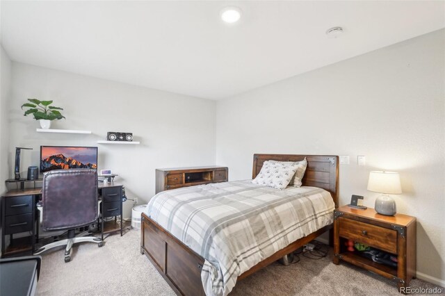 carpeted bedroom featuring a desk and baseboards