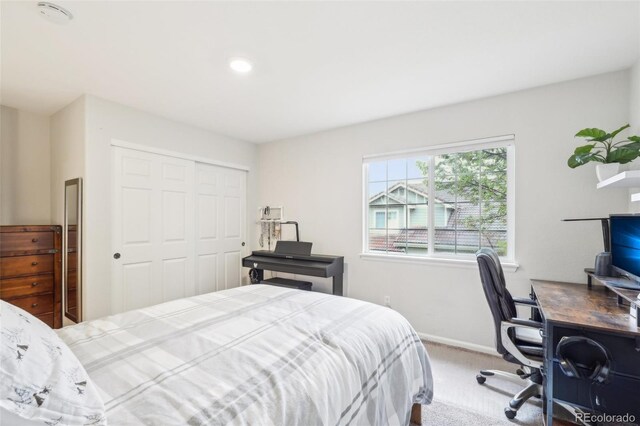bedroom featuring carpet flooring, a closet, a desk, and baseboards